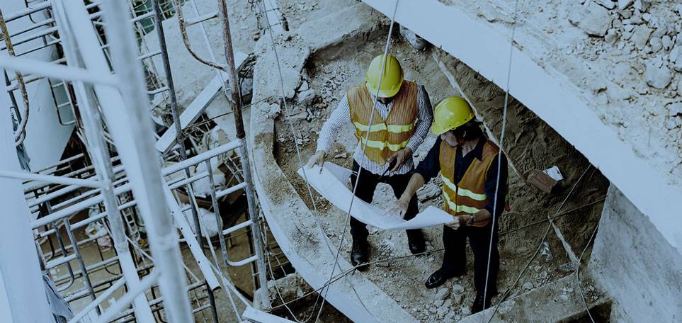 Construction workers looking over blue print on work site